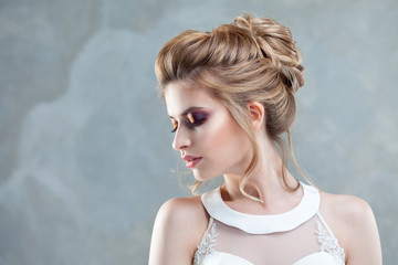 Young beautiful bride with an elegant high hairdo. Wedding hairstyle with the accessory in her hair