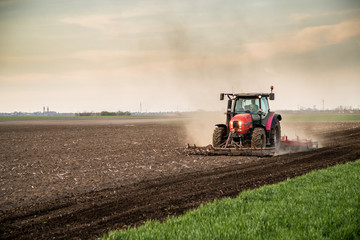 Tractor cultivating field at spring