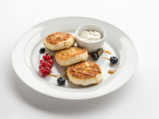 pancakes made of cottage cheese with sour cream and berries