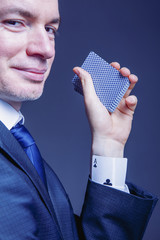 A partial view of a businessman with a card in a sleeve as symbol of cheating and dishonest games (Business, fraud, profit, crime, money laundering concept)