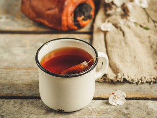 tea brew in a cup (tea bag) on ​​a wooden table and flowering spring twigs. Food background -...