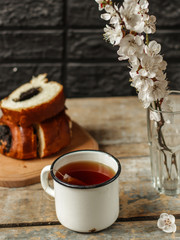 tea brew in a cup (tea bag) on ​​a wooden table and flowering spring twigs. Food background - drink background
