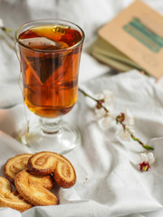 tea brew in a cup (tea bag) on ​​a wooden table and flowering spring twigs. Food background - drink background