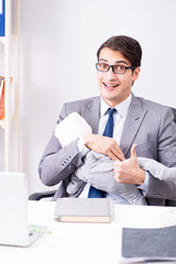 Businessman looking after newborn baby in office