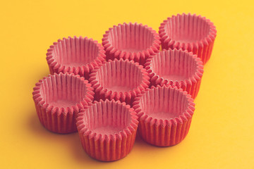 arrangement of pink small cupcake tray holders on yellow