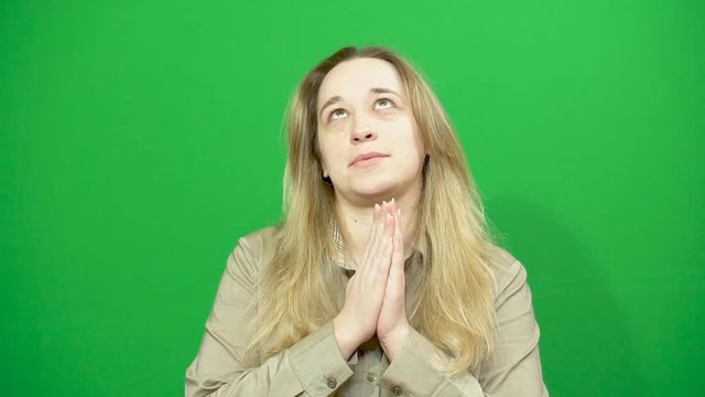 Young girl posing. She emotionally tells the interlocutor news. Green background.