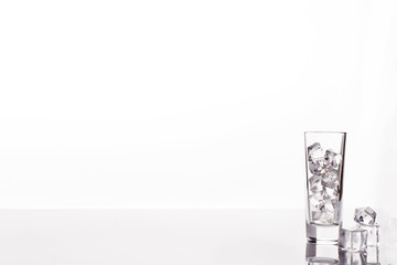 glass with ice cubes on white background