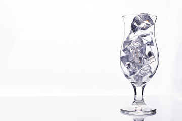 glass with ice cubes on white background