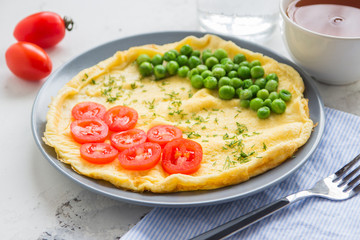 Omelette with green peas and cherry tomatoes. Protein breakfast