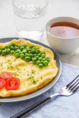 Omelette with green peas and cherry tomatoes. Protein breakfast