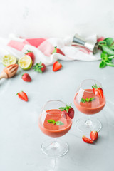 Alcohol cocktail with vodka, strawberry, lime, basil and ice