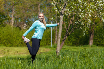Young woman is stretching in a sport dress