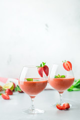 Alcohol cocktail with vodka, strawberry, lime, basil and ice