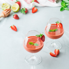 Alcohol cocktail with vodka, strawberry, lime, basil and ice