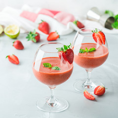 Alcohol cocktail with vodka, strawberry, lime, basil and ice