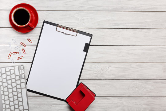 white table boards folder red notebook cup of coffee clock paper clips keyboard mouse office desk