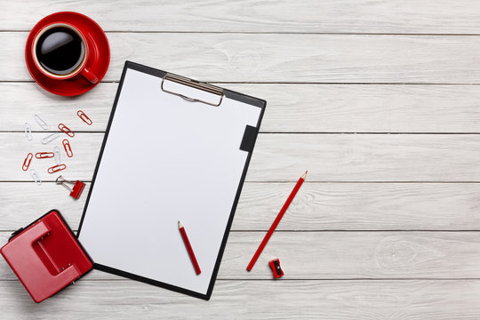 white table boards folder red notebook cup of coffee clock paper clips keyboard mouse office desk