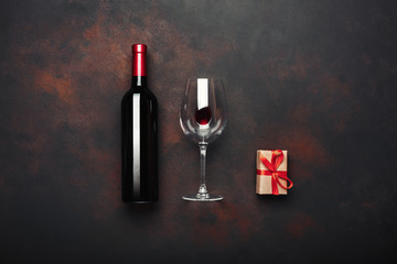 Bottle of wine gift box corkscrew and wineglass on rusty background