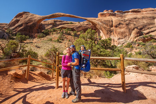 A family with baby son visits Arches National Park in Utah, USA