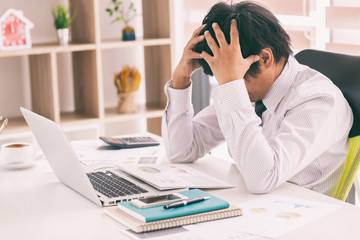 The man are stressed at work in the office. Asian businessman stressful and headache with laptop computer. Young male with headache at office, feeling sick at work.