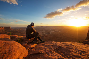 Hiker meets sunset at Grand view point in Canyonlands National park in Utah, USA