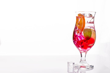 Pink and red Fresh colorful exotic alcoholic cocktail with lemon and ice on white