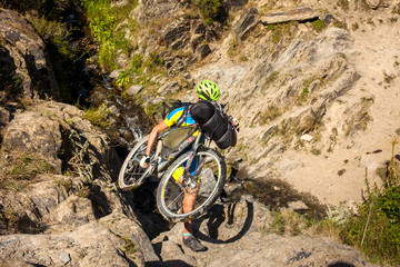 Biker pushes his bicycle up in high Caucasus mountains