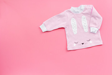 Clothes for newborn and small children on pink background top view space for text