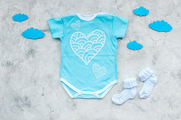 Newborn baby's sleep concept. To put the child to bed. Baby bodysuit near clouds on grey background...