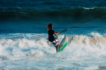 Kitesurfer jumping on a beautiful background of spray during the sunset