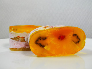  bright cake with lemon, orange kiwi close-up on white background, dessert, cake, cake, cream, jelly, delicious, holiday, white, close-up, tasty, sweet, jelly, berries, pastry, currant, lemon, orange,