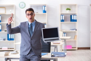 Young handsome businessman employee working in office at desk