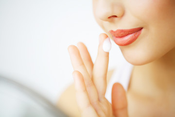 Obraz premium Beauty Face Care. Woman Applying Cream On Skin.
