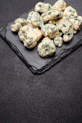 Slice of French Roquefort cheese on stone board