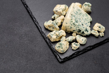 Slice of French Roquefort cheese on stone board