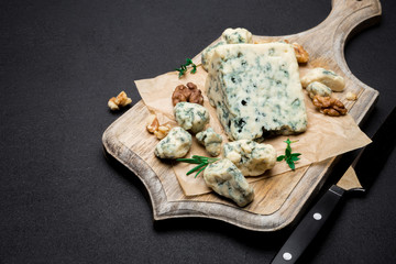 Slice of French Roquefort cheese on wooden board