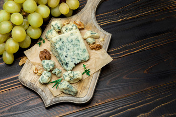 Slice of French Roquefort cheese on wooden board