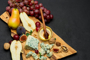 Slice of French Roquefort cheese and pear on wooden board