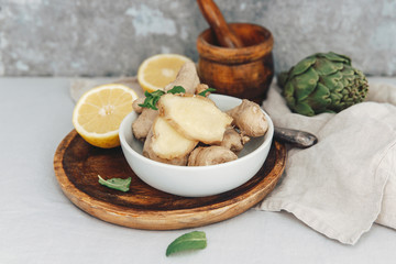 Ginger root and slices  in bowl with linen napkin