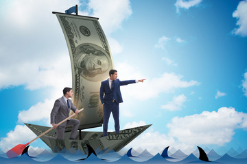 Businessman rowing on dollar boat in business financial concept