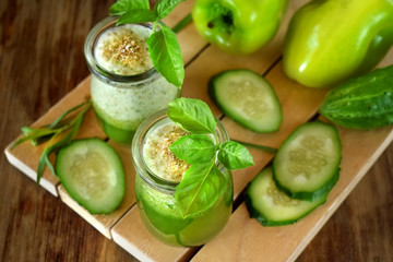 Green smoothie in a glass jar sprinkled with brans decorated with basil