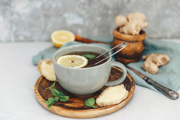 Fototapeta na wymiar Hot tea with lemon and ginger on rustic scene