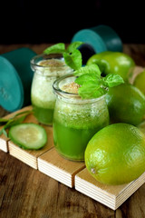 Green smoothie in a glass jar sprinkled with brans decorated with basil