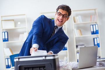 Businessman angry at copying machine jamming papers