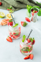 Alcohol cocktail mojito lemonade with rum, soda, strawberry and basil
