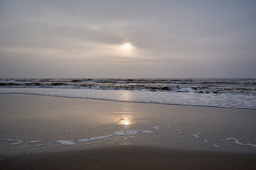 Calming sunset and reflection of the sun at the north sea in early spring, Netherlands