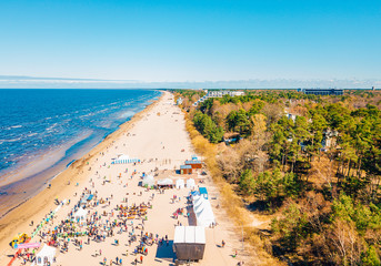 Aerial view from drone on crowd of people who is starting are running on marathon event by the sea...