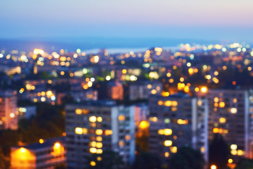 Blurred view from a bird's eye view to a modern night city. Bright lights of high buildings of...