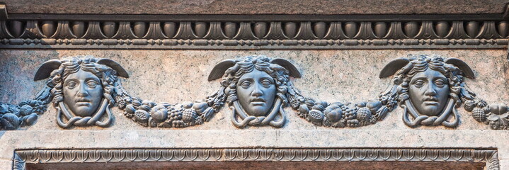 Decorative bas-relief in the form of antique masks of God Mercury (Hermes)