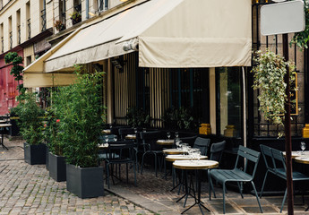 Typical view of the Parisian street with tables of brasserie (cafe) in Paris, France